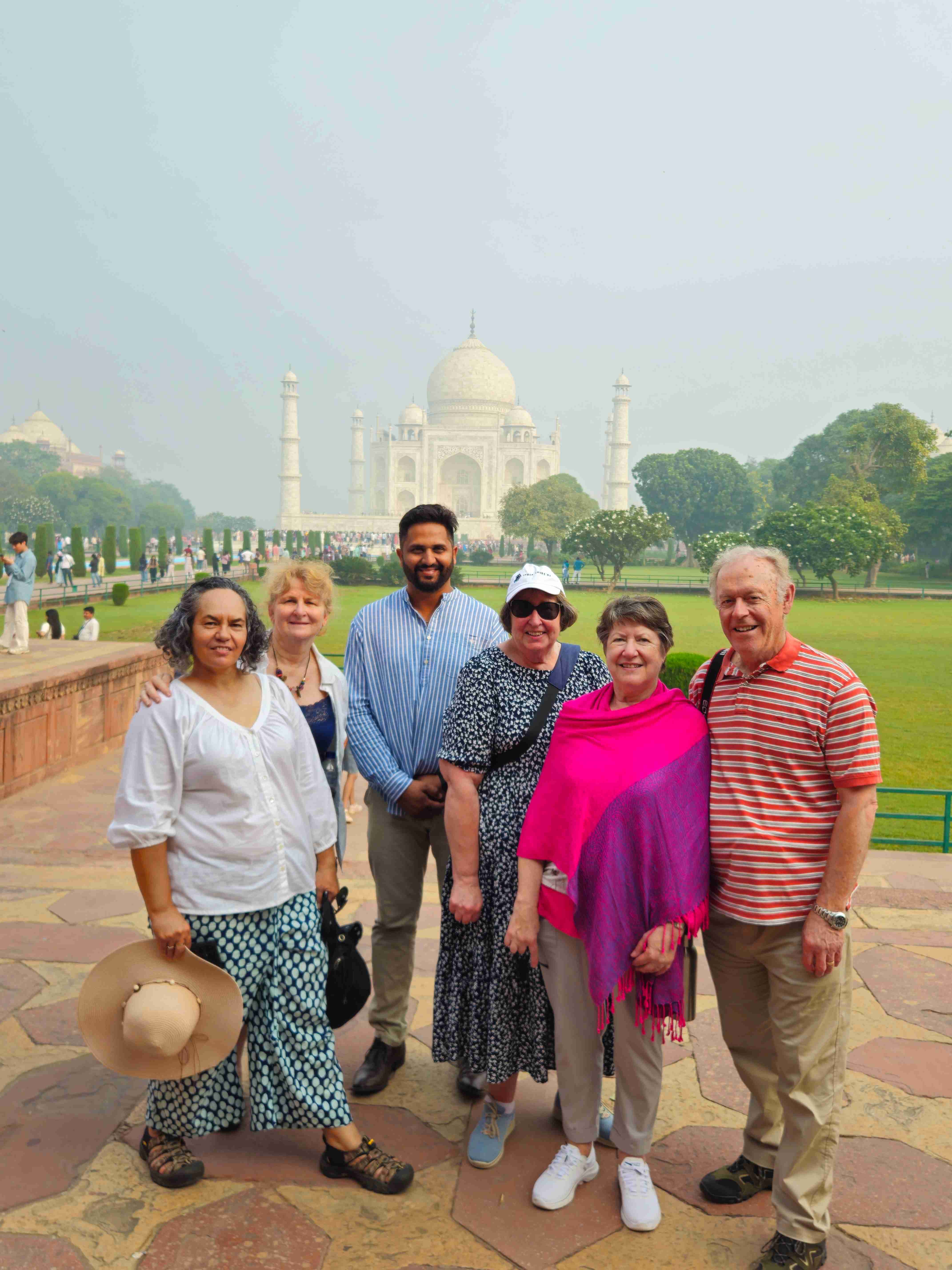 A group of tourists poses in front of the Taj Mahal, capturing a memorable moment during their India tour in September 2018